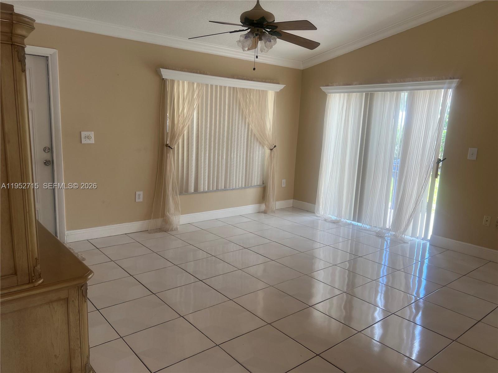 5827 Northwest 197th Terrace Hialeah, FL 33015 - Photo 7 of 30 a view of a livingroom with a chandelier fan and windows