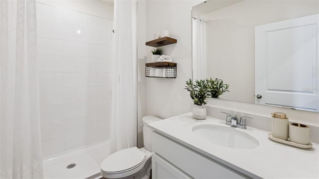 2869 House Finch Road St. Cloud, FL 34773 - Photo 17 of 56 a bathroom with a sink a toilet and shower