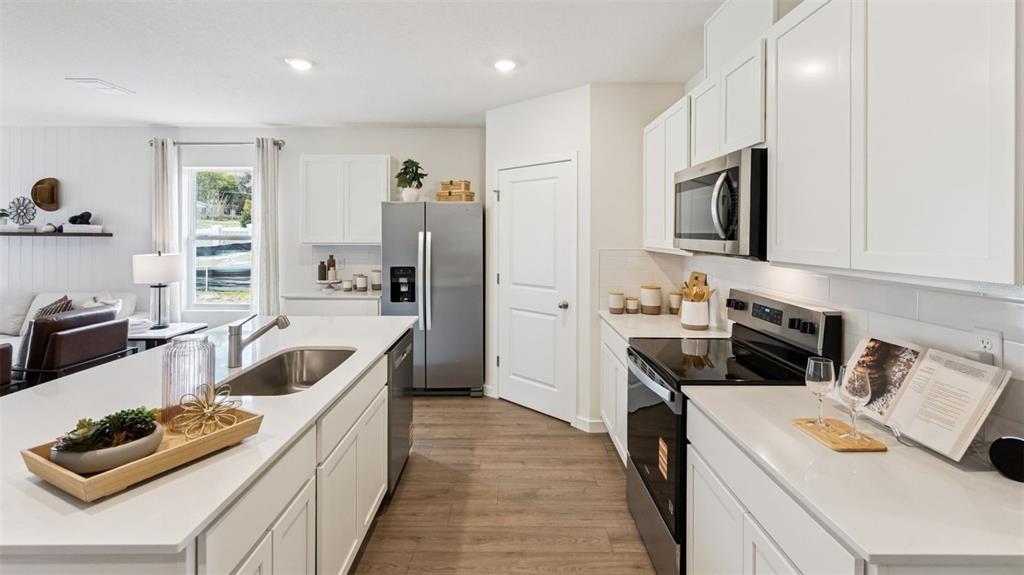 2869 House Finch Road St. Cloud, FL 34773 - Photo 5 of 56 a kitchen that has a sink and a stove top oven