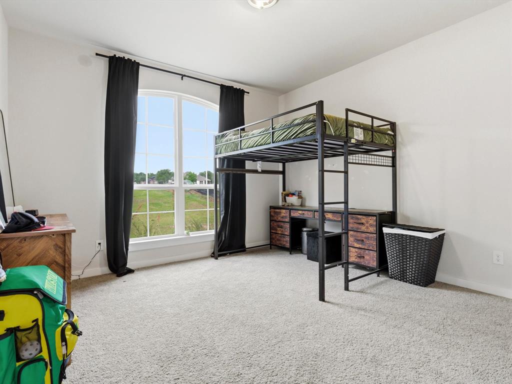 155 Rj Smith Drive Boyd, TX 76023 - Photo 27 of 37 Comfortable secondary bedroom faces the street, with natural light and ample closet space.