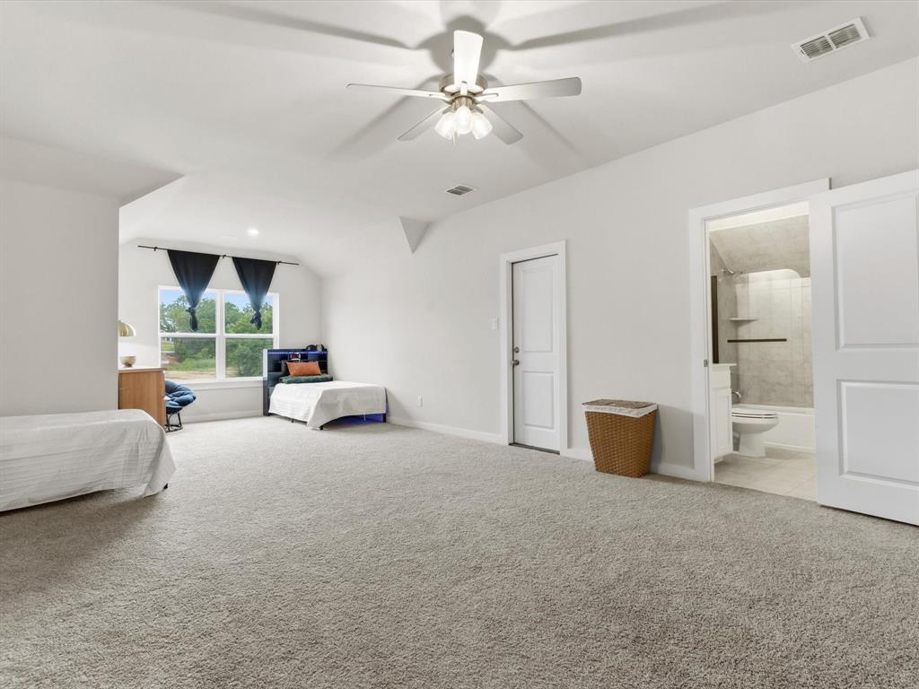 155 Rj Smith Drive Boyd, TX 76023 - Photo 30 of 37 Versatile bonus room upstairs with en-suite bathroom, perfect for large second primary, media room, game room, or additional living space.