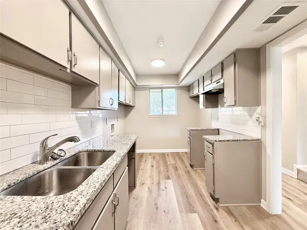 a kitchen with a sink stove and cabinets