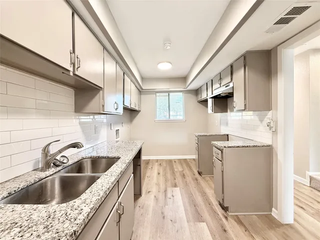 a kitchen with a sink stove and cabinets