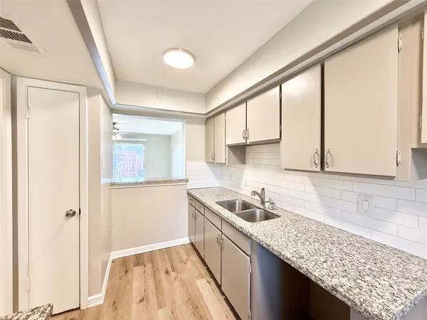 a kitchen that has a sink a stove and cabinets in it