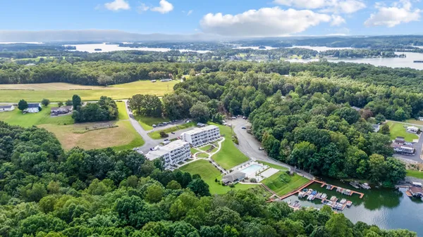 an aerial view of a house with a garden and lake view