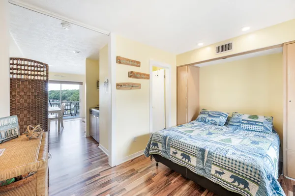a bedroom with a bed and wooden floor