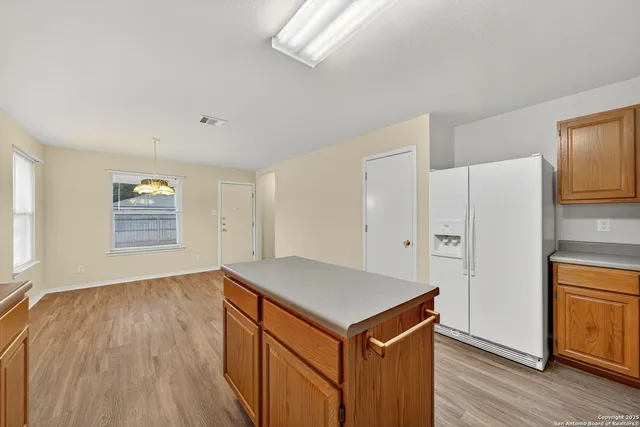 a kitchen with cabinets and wooden floor