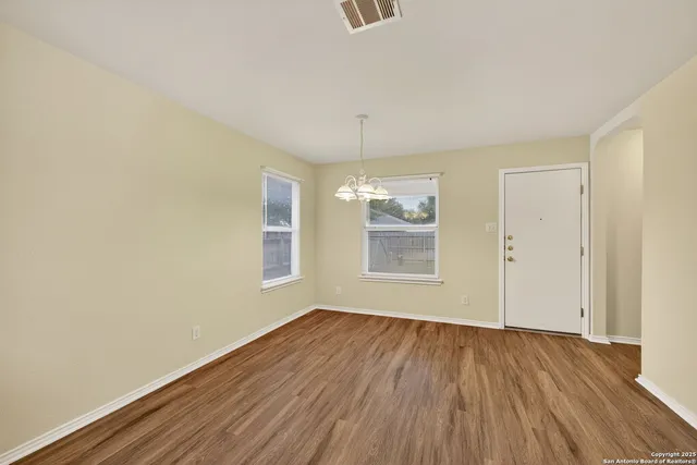 a view of a kitchen with cabinets and wooden floor