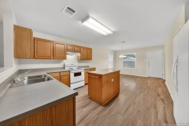 a view of kitchen with stainless steel appliances cabinets and wooden floor