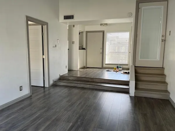 a view of a room with wooden floor and window