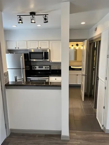 a kitchen with stainless steel appliances a stove a microwave and a sink