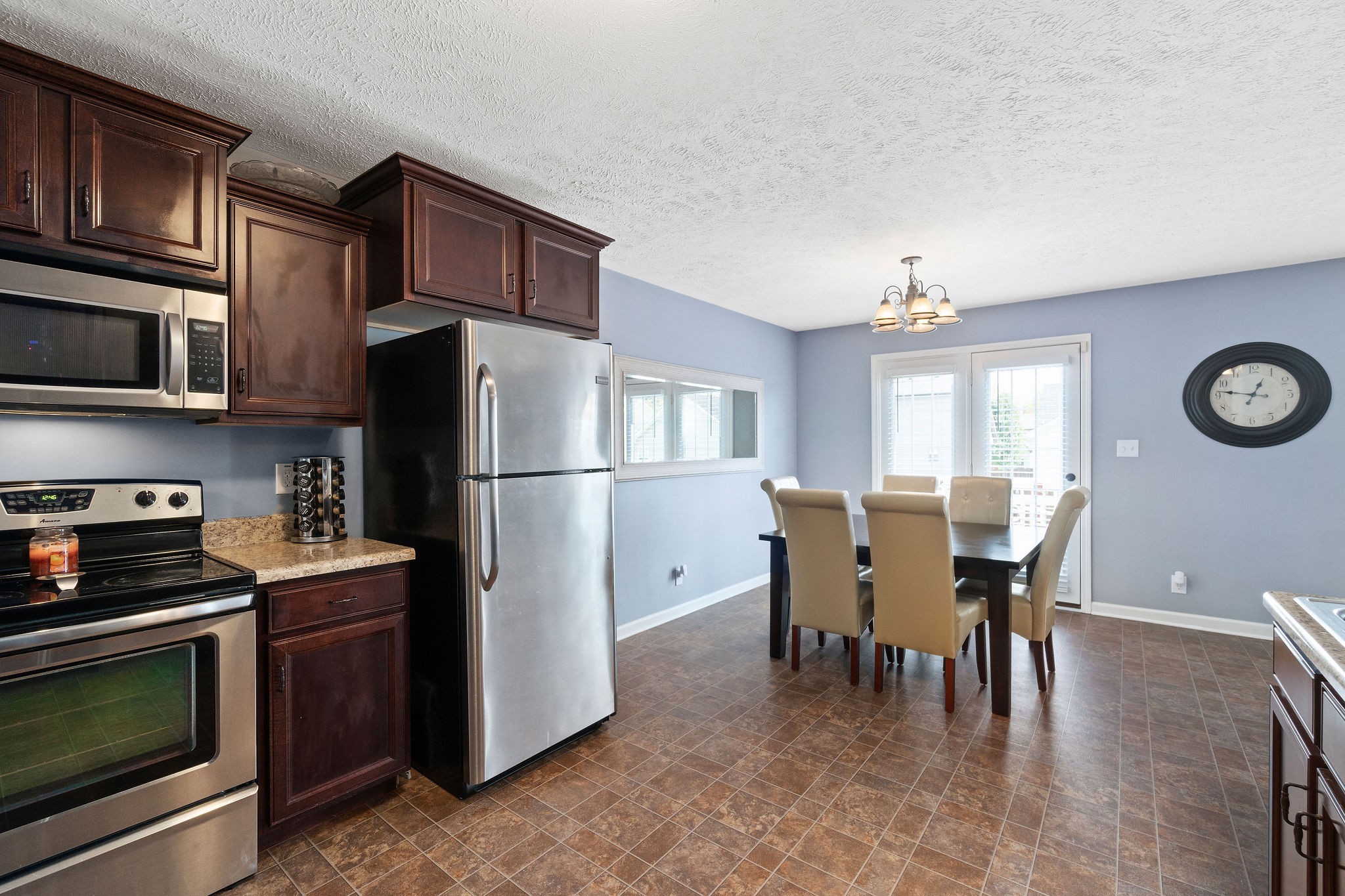 3743 Suiter Road Clarksville, TN 37040 - Photo 12 of 32 a kitchen with stainless steel appliances granite countertop a refrigerator a stove a microwave oven a dining table and chairs with wooden floor