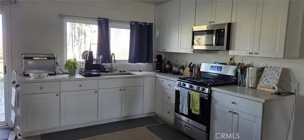 a kitchen with stainless steel appliances granite countertop a sink a stove and a microwave