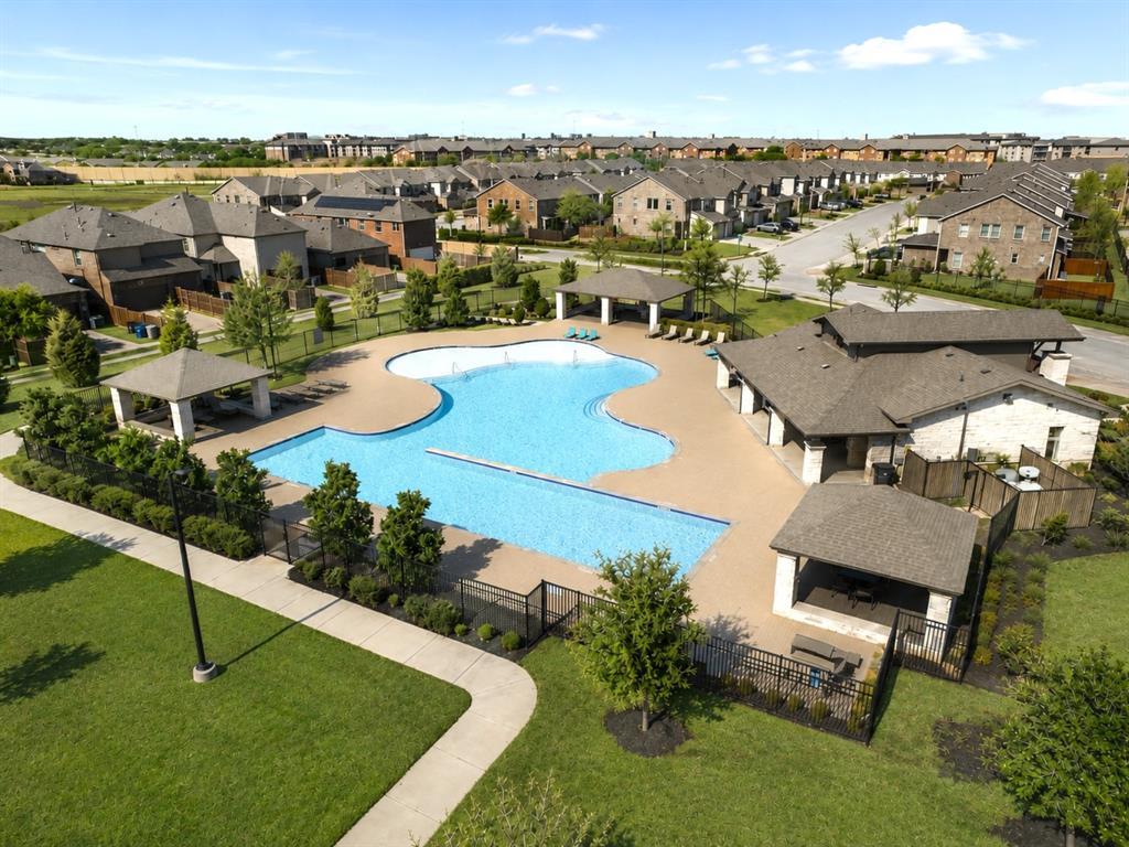 8235 Snapdragon Way Dallas, TX 75252 - Photo 29 of 29 Resort-style pool area featuring multiple shaded cabanas, extensive paved decking, and a stone-clad clubhouse structure