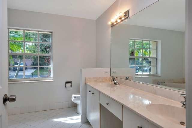4821 North Lee Road Delray Beach, FL 33445 - Photo 17 of 33 a bathroom with a granite countertop sink a toilet and a window