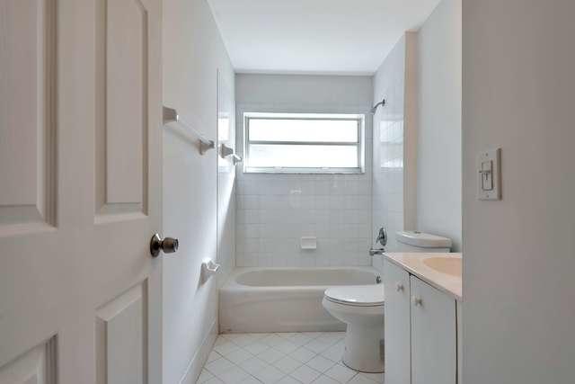 4821 North Lee Road Delray Beach, FL 33445 - Photo 26 of 33 a bathroom with a granite countertop toilet a sink and a bathtub