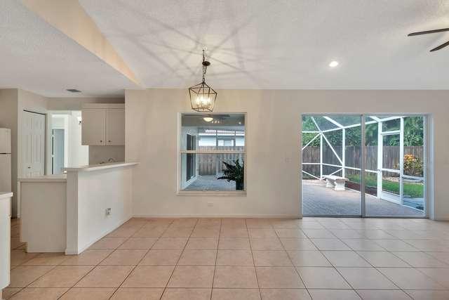 4821 North Lee Road Delray Beach, FL 33445 - Photo 10 of 33 a large white kitchen with windows and chandelier