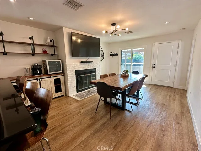 a view of a dining room with furniture a fireplace and wooden floor