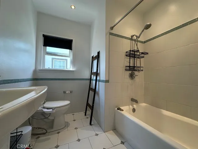 a bath tub sitting next to a white toilet and a sink