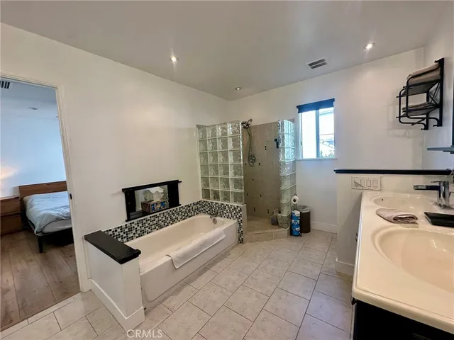 a white bed sitting in a bedroom next to a window with pc on the table