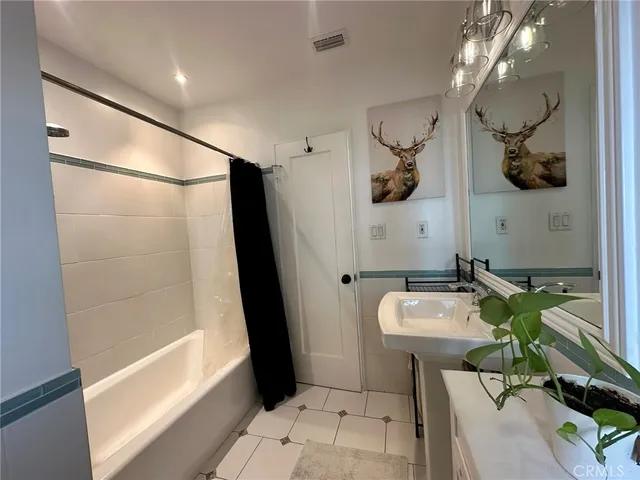 a bathroom with a bathtub a sink and a mirror