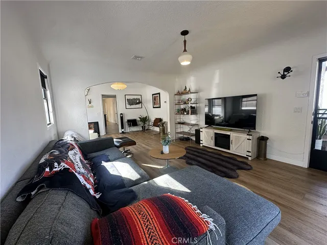a living room with furniture flat screen tv and wooden floor