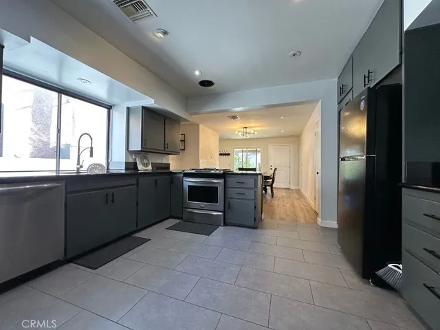 a large kitchen with granite countertop a stove a refrigerator and a sink