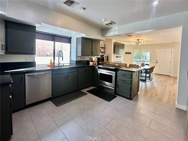 a kitchen with stainless steel appliances granite countertop a stove sink and cabinets