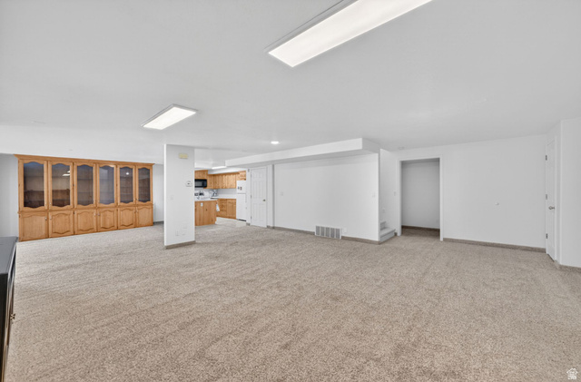 883 East 700 South Springville, UT 84663 - Photo 37 of 59 Expansive carpeted area featuring a full wall of built-in wood cabinetry with glass-front display sections