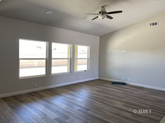 420 Thomas Street Ridgecrest, CA 93555 - Photo 2 of 13 wooden floor in an empty room with a window