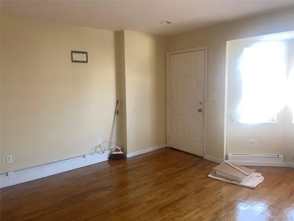 an empty room with wooden floor and window
