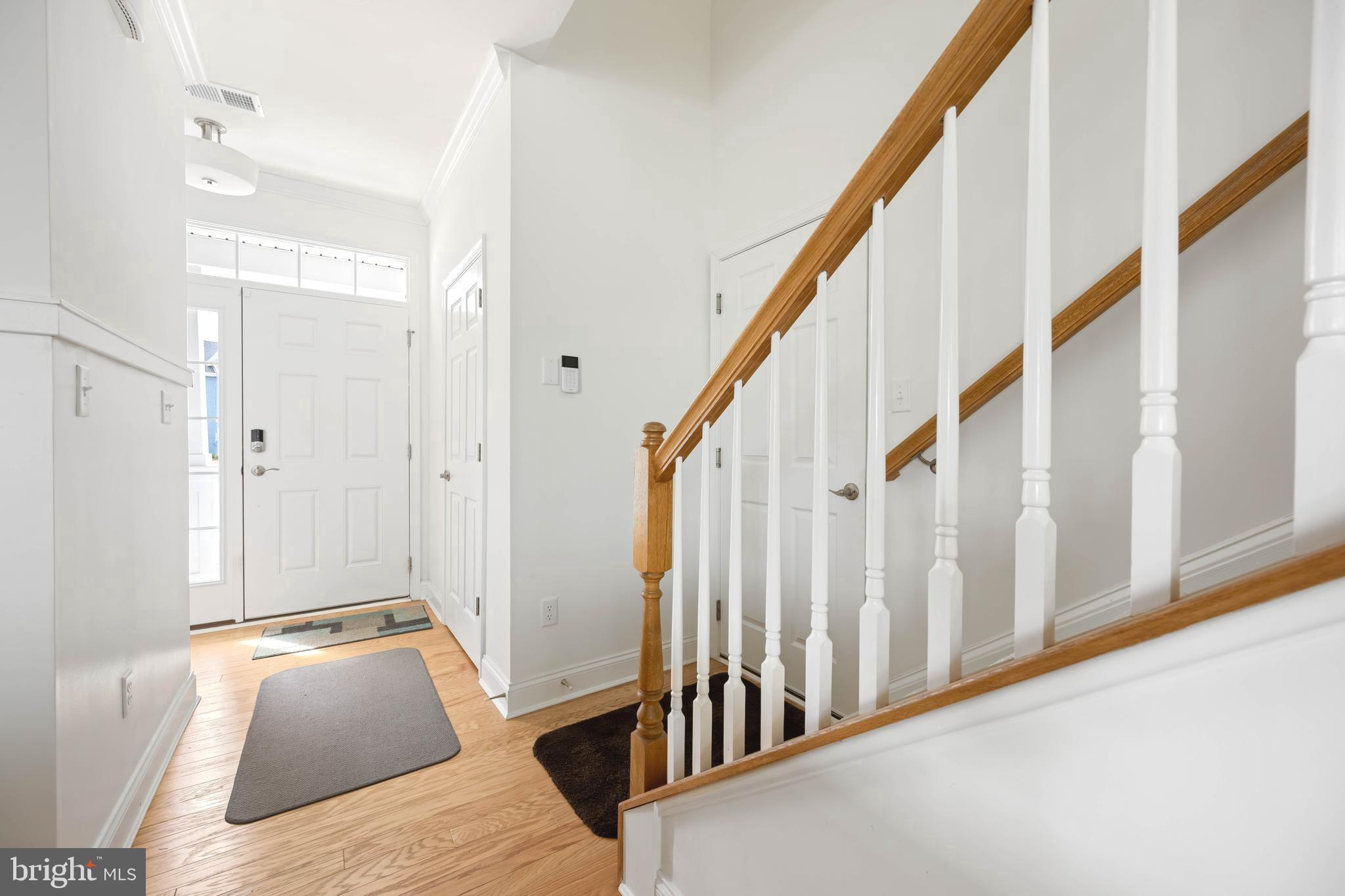 25304 Razorbill Court Millsboro, DE 19966 - Photo 3 of 45 a view of a hallway with wooden floor and staircase
