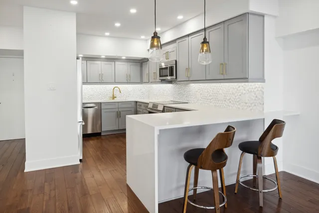 a kitchen with cabinets and chairs