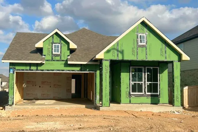 a front view of a house with a garden and yard