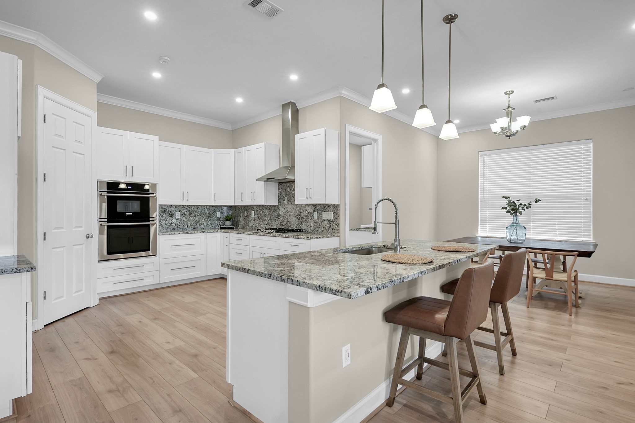 121 Bermuda Circle Montgomery, TX 77356 - Photo 14 of 44 a kitchen with stainless steel appliances granite countertop a stove a sink a dining table and chairs with wooden floor