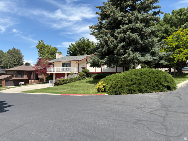 595 Meadowlark Road Orem, UT 84097 - Photo 84 of 87 Multi-level residence featuring a prominent balcony with white railing, a red accent foundation, and a neutral-toned exterior