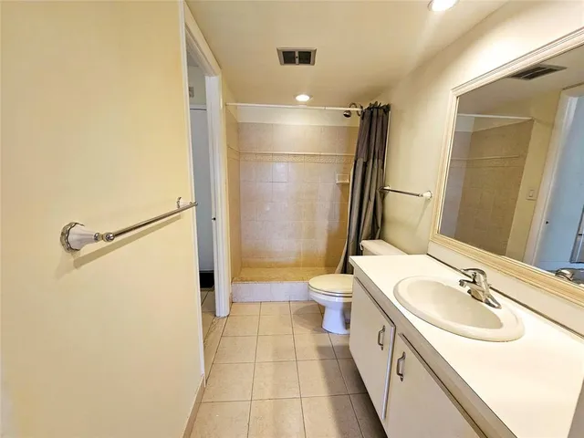 an empty room with windows and ceiling fan