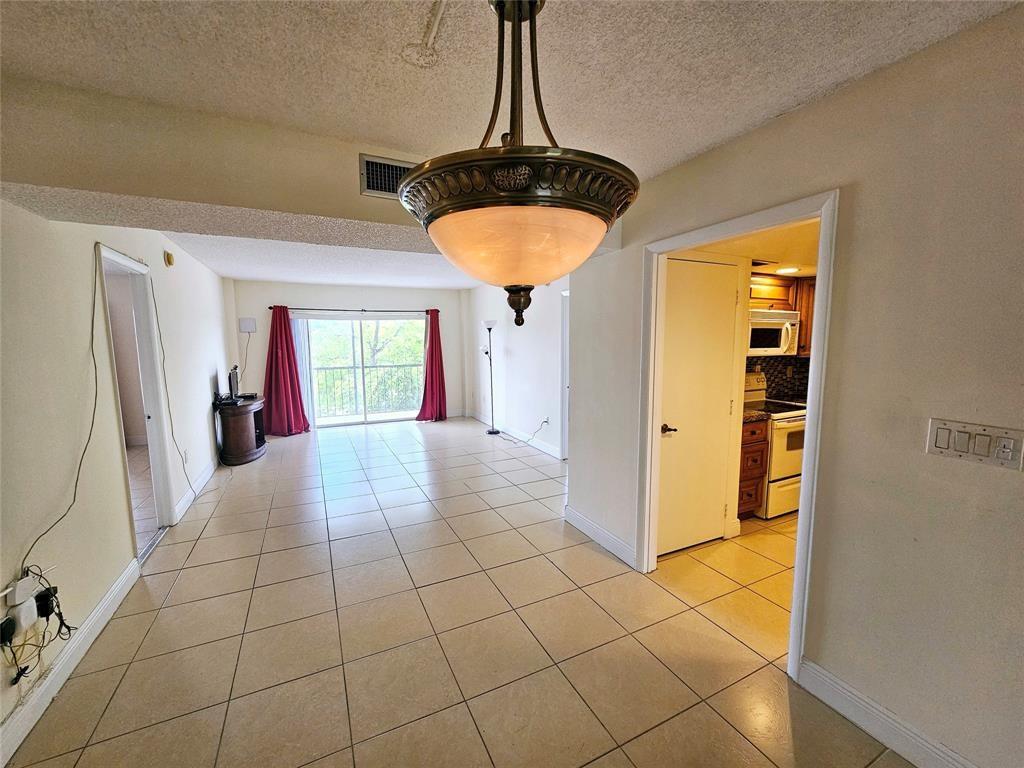 4172 Inverrary Drive, Unit 410 Lauderhill, FL 33319 - Photo 6 of 23 a view of an empty room with window and chandelier fan