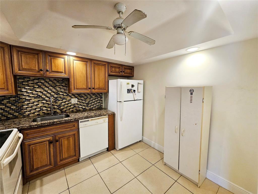 4172 Inverrary Drive, Unit 410 Lauderhill, FL 33319 - Photo 8 of 23 a kitchen with stainless steel appliances granite countertop a refrigerator and a stove top oven