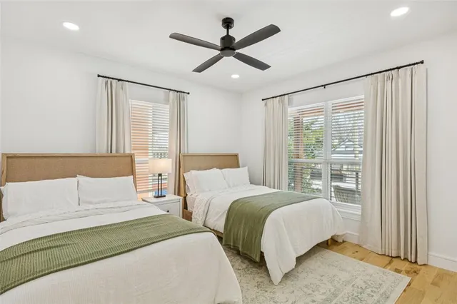 a bedroom with two large bed and a ceiling fan