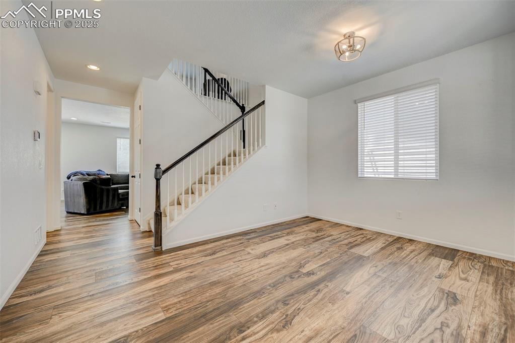 6237 Bodacious Circle Colorado Springs, CO 80923 - Photo 2 of 33 Unfurnished living room featuring wood finished floors, stairway, and recessed lighting