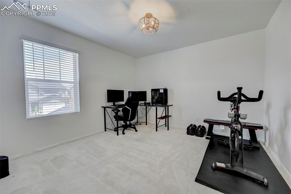 6237 Bodacious Circle Colorado Springs, CO 80923 - Photo 27 of 33 Workout room with a chandelier and carpet flooring