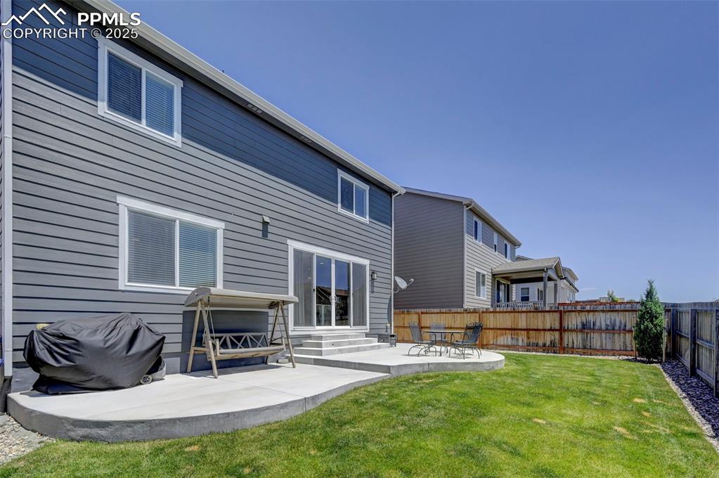 6237 Bodacious Circle Colorado Springs, CO 80923 - Photo 30 of 33 Back of house featuring entry steps, a fenced backyard, and a patio