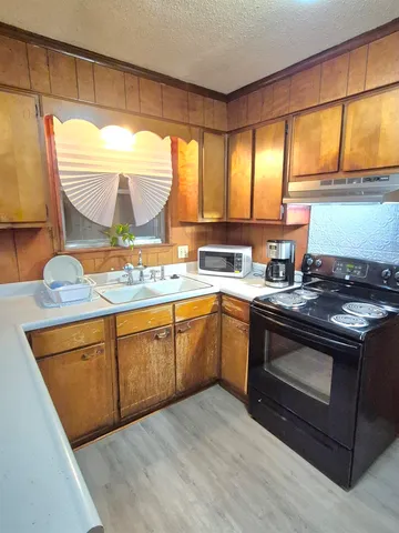 a kitchen with stainless steel appliances kitchen island granite countertop a stove a sink and a refrigerator