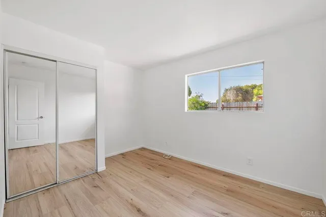 an empty room with wooden floor and closet