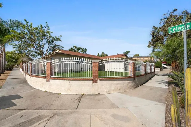 a view of a brick house with wooden fence