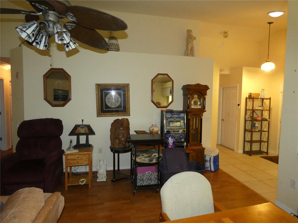 13541 Knotty Lane Hudson, FL 34669 - Photo 13 of 32 a living room with couches chair and a clock on the wall