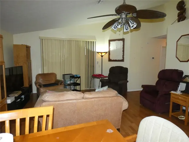 a living room with furniture a chandelier and a flat screen tv