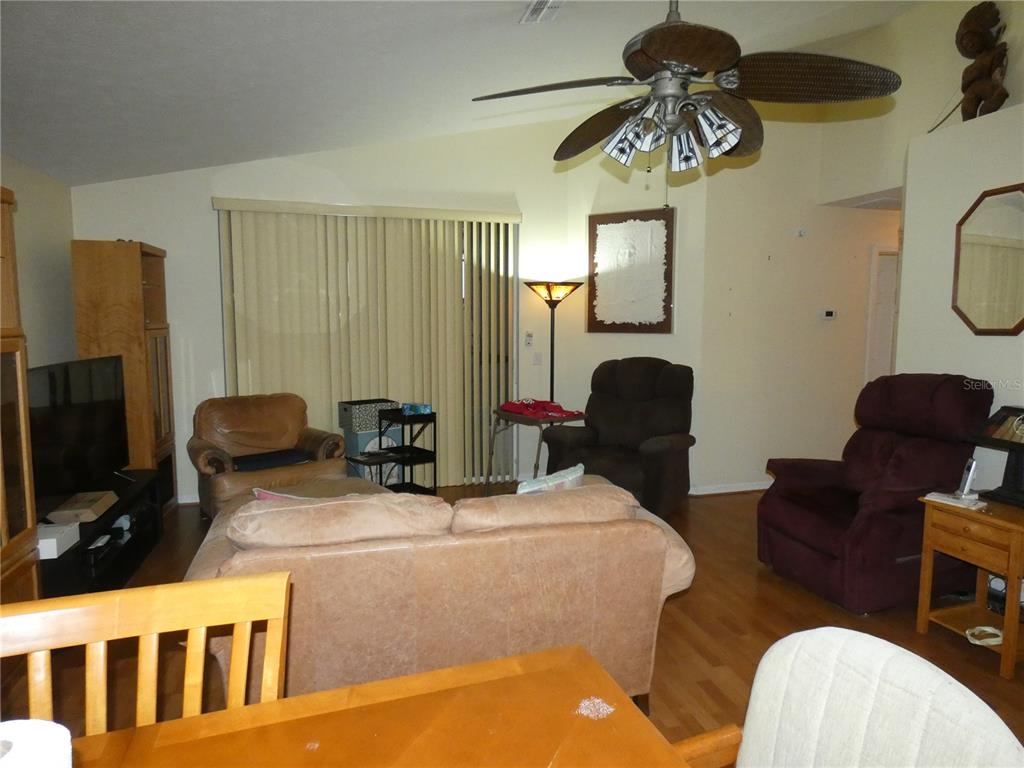 13541 Knotty Lane Hudson, FL 34669 - Photo 14 of 32 a living room with furniture a chandelier and a flat screen tv