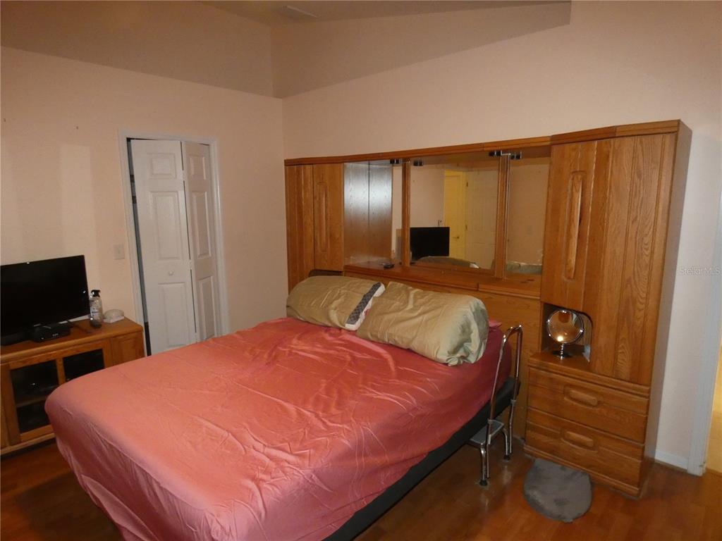 13541 Knotty Lane Hudson, FL 34669 - Photo 16 of 32 a bedroom with a bed and a flat screen tv